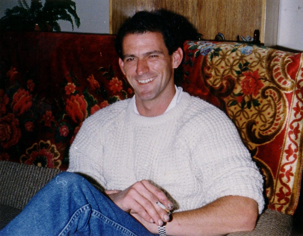 Steve Whitty smiling, seated in an armchair